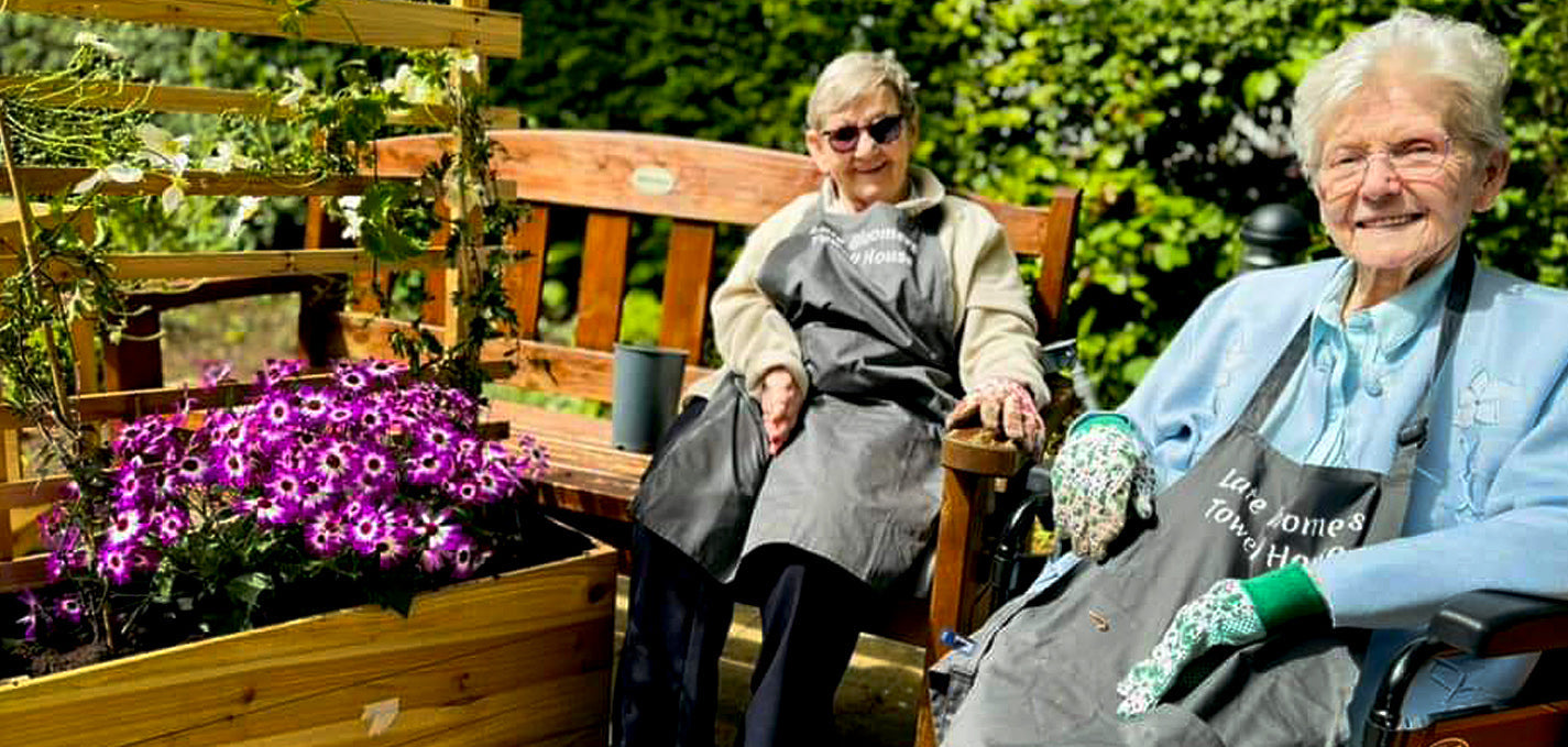 Elderly residents tending raised garden beds at Towell House care home in East Belfast