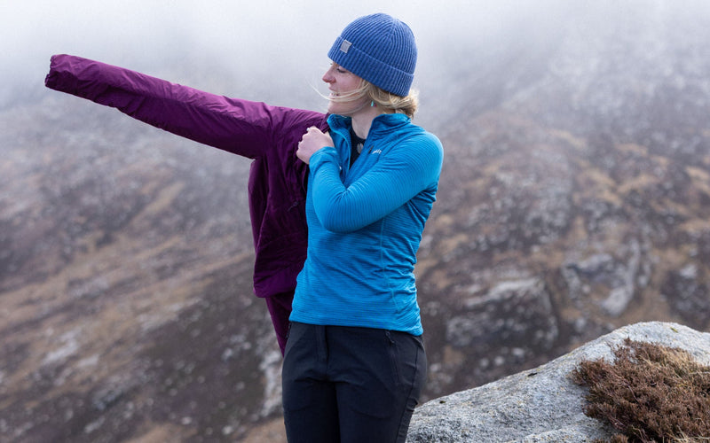 Hikers pulls on a waterproof with rain approaching
