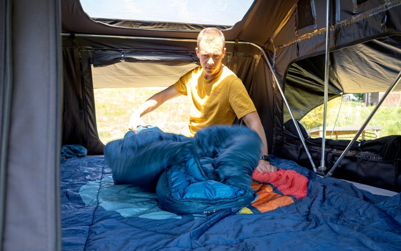 Camper preparing his sleeping bag