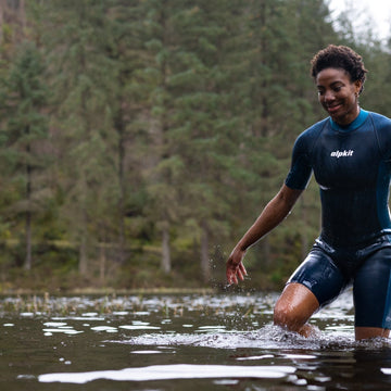 Outdoor swimmers entering the water in wetsuits